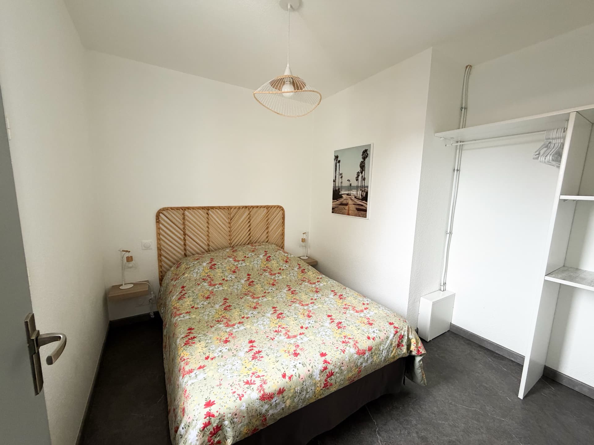 Chambre principale avec lit double et tête de lit en rotin tressé