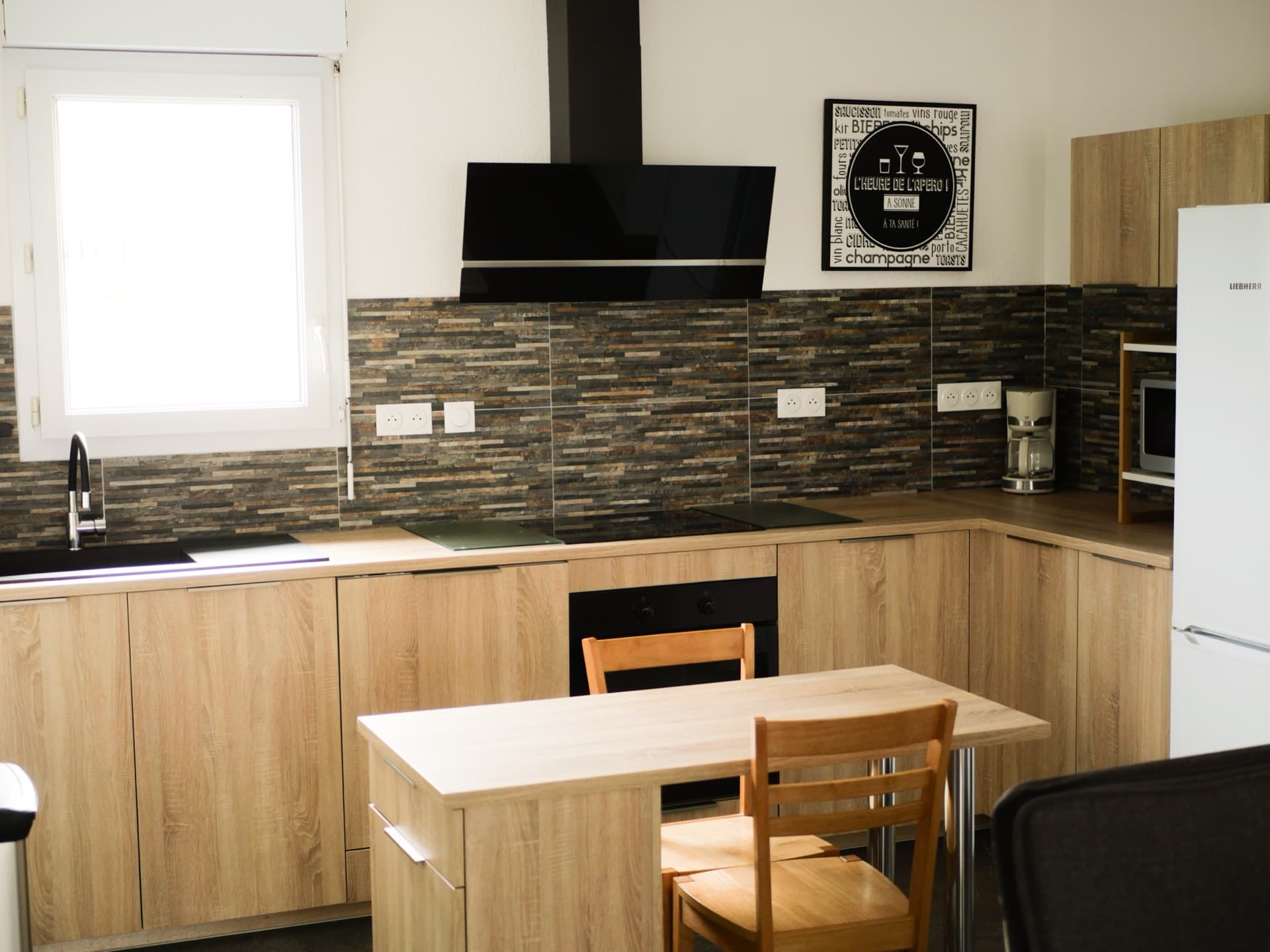 Cuisine équipée en U avec hotte, plaque induction et coin repas en bois